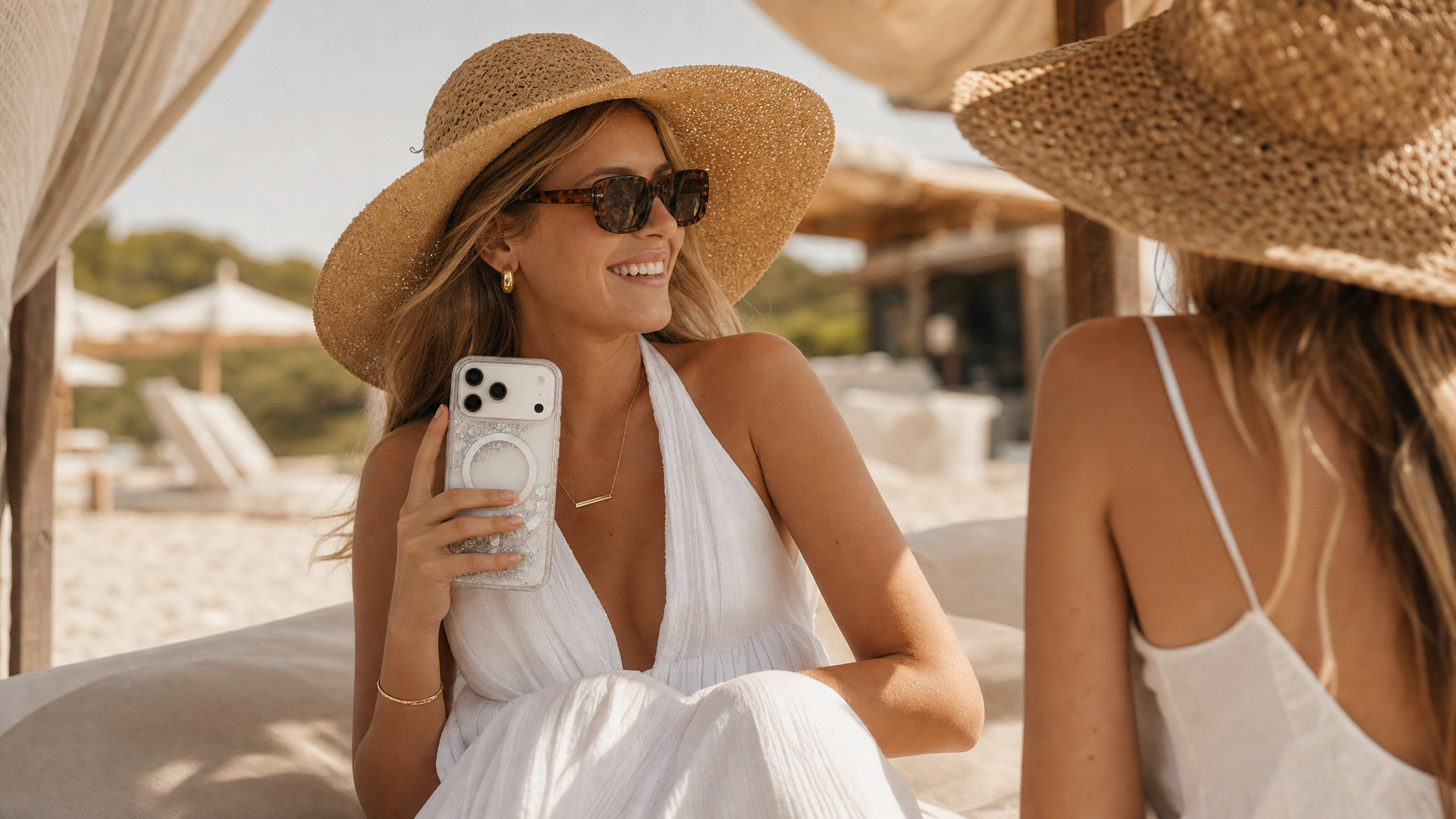 Woman in sunhat holding glitter phone case at beach