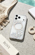 Clear pearlescent phone case flat lay with beach accessories