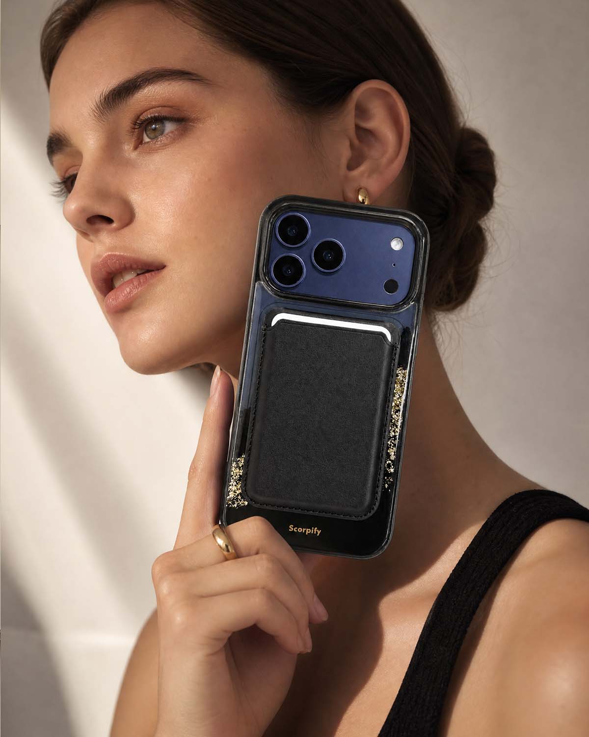 Woman holding iPhone with classic black phone wallet
