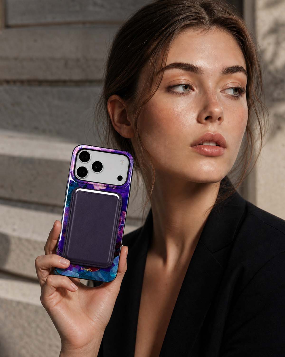 Woman in black blazer holding dark cherry phone wallet