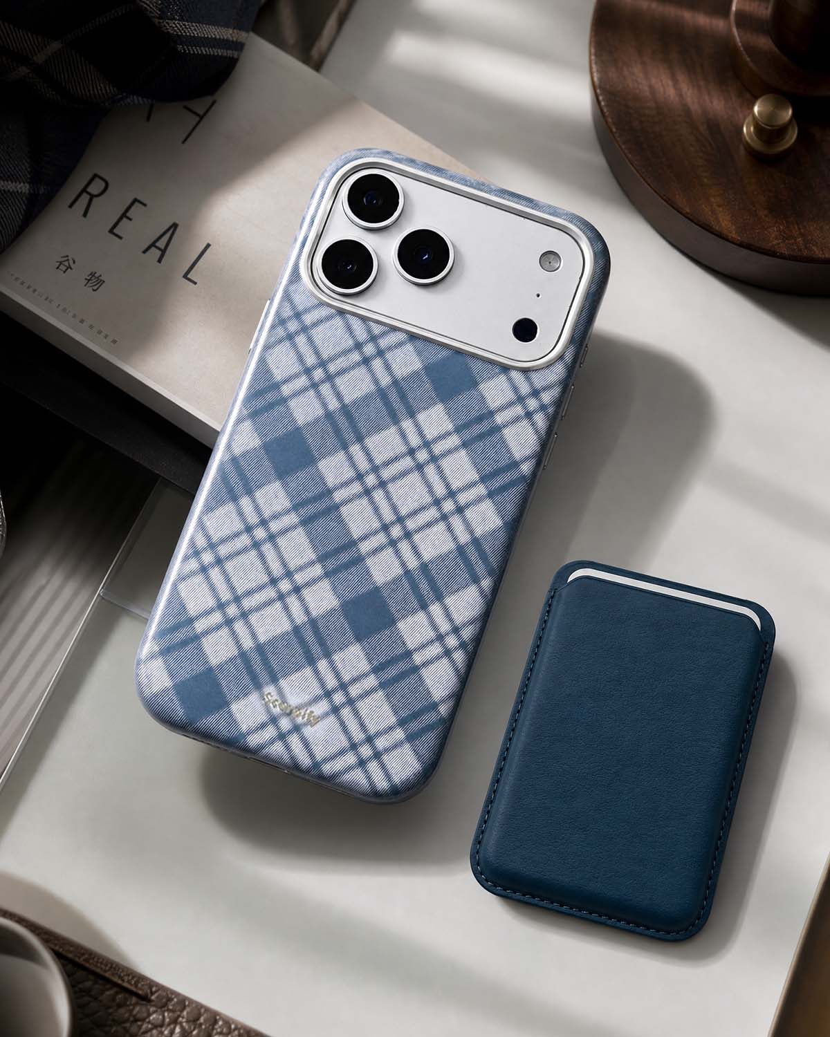 Storm blue phone wallet beside plaid iPhone case