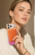 Woman holding iPhone with cosmic orange phone wallet