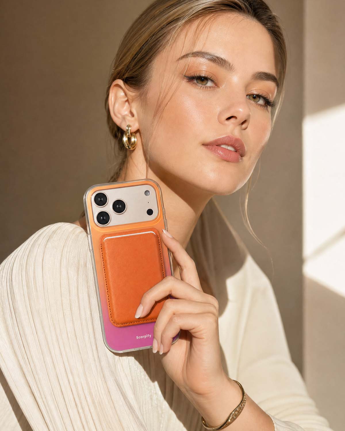 Woman holding iPhone with cosmic orange phone wallet