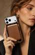 Woman in black blazer holding classic brown phone wallet