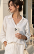 Woman in white outfit holding ivory swirl leather phone case