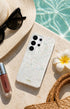 Glitter Samsung phone case on beach with sunhat and flower
