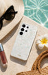 Glitter Samsung phone case on beach with sunhat and flower