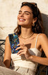 Young woman holding glitter phone case outdoors