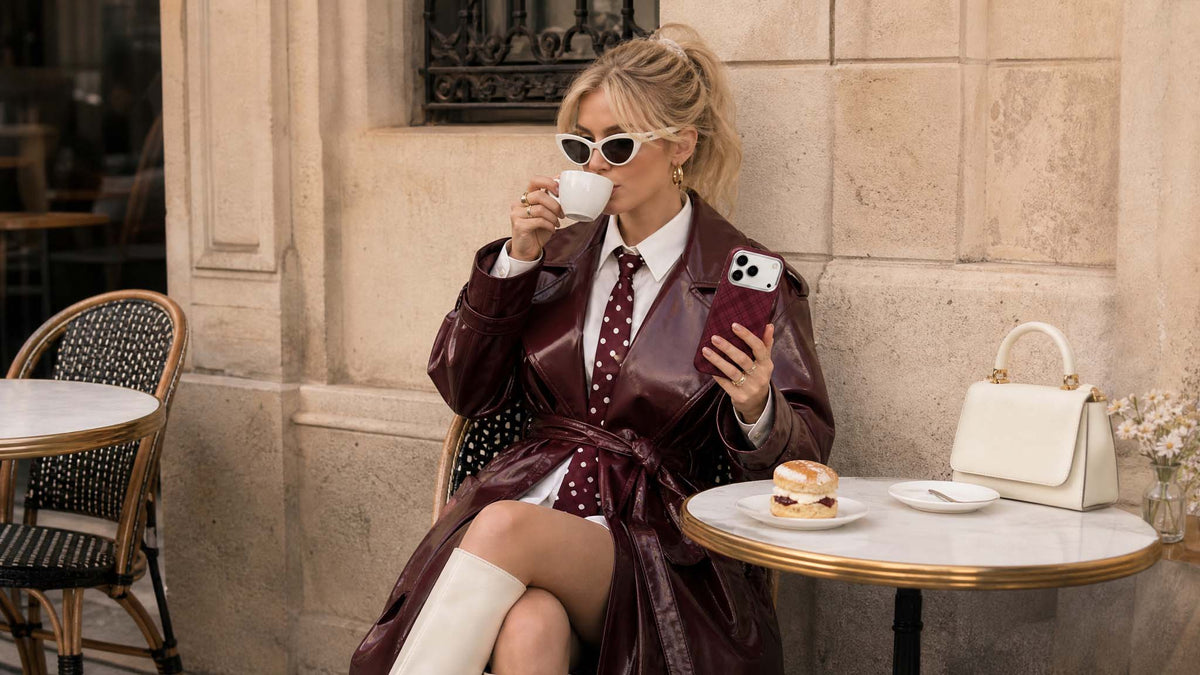 Woman in burgundy coat holding tartan leather phone case