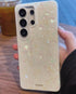 Hand holding pearl Samsung phone case on table