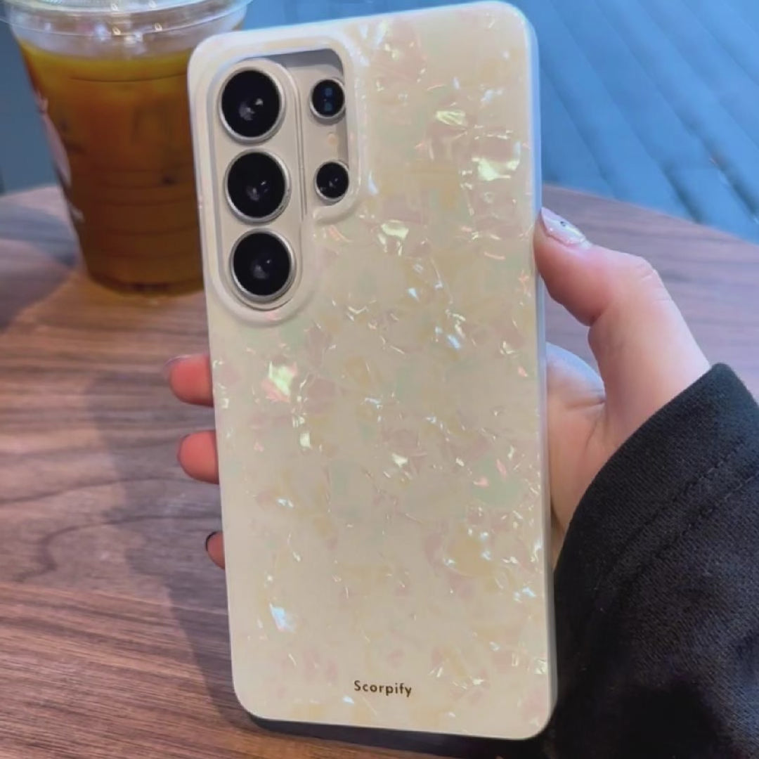 Hand holding pearl Samsung phone case on table