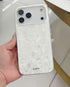 Hand holding white pearl phone case with shimmer texture