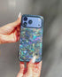 Woman's hand holding blue glitter phone case with swirl pattern