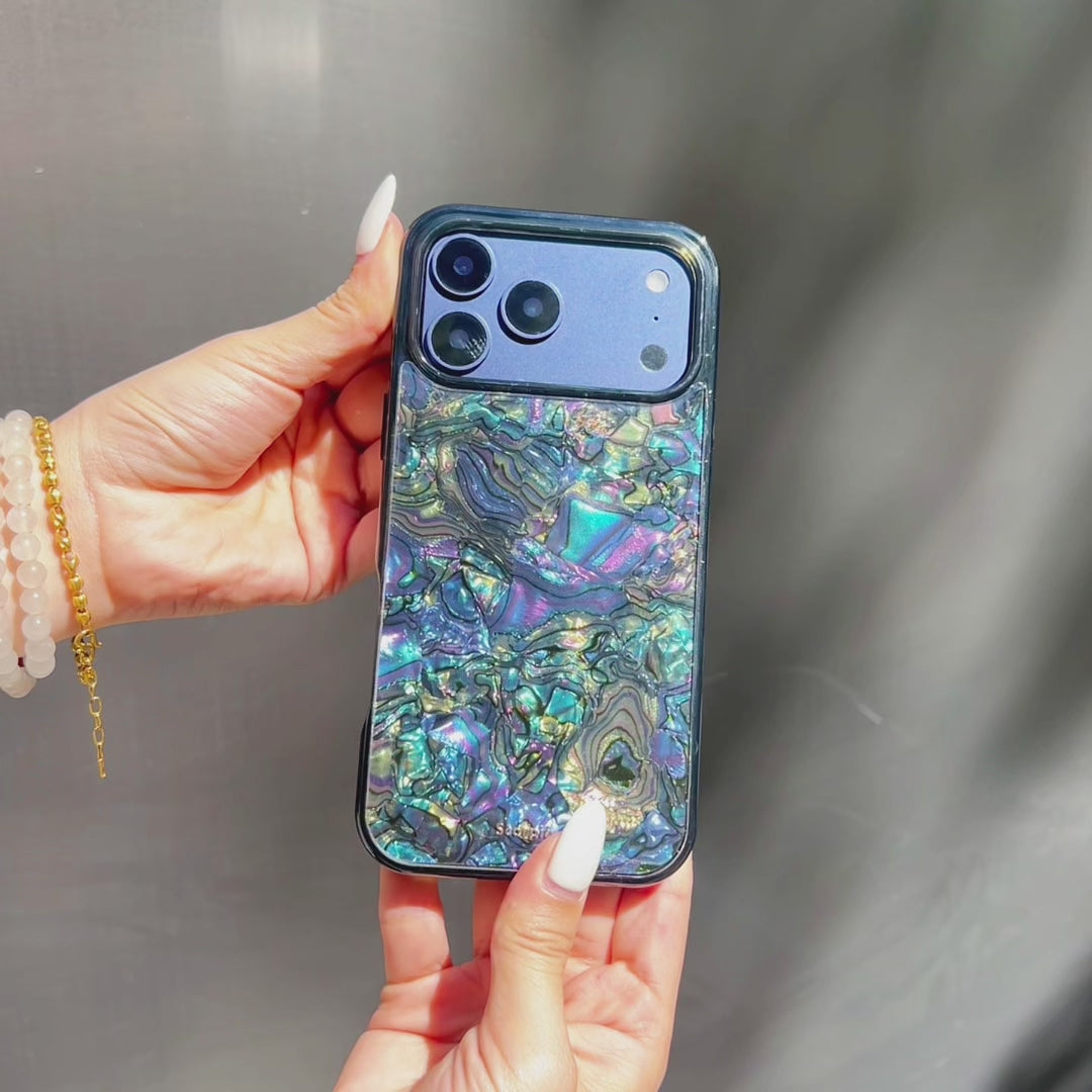 Woman's hand holding blue glitter phone case with swirl pattern