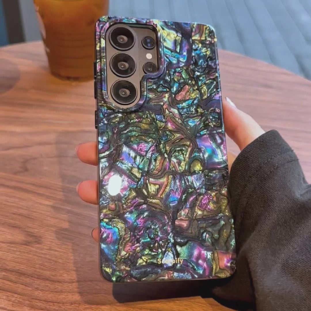 Hand holding iridescent phone case showing shine